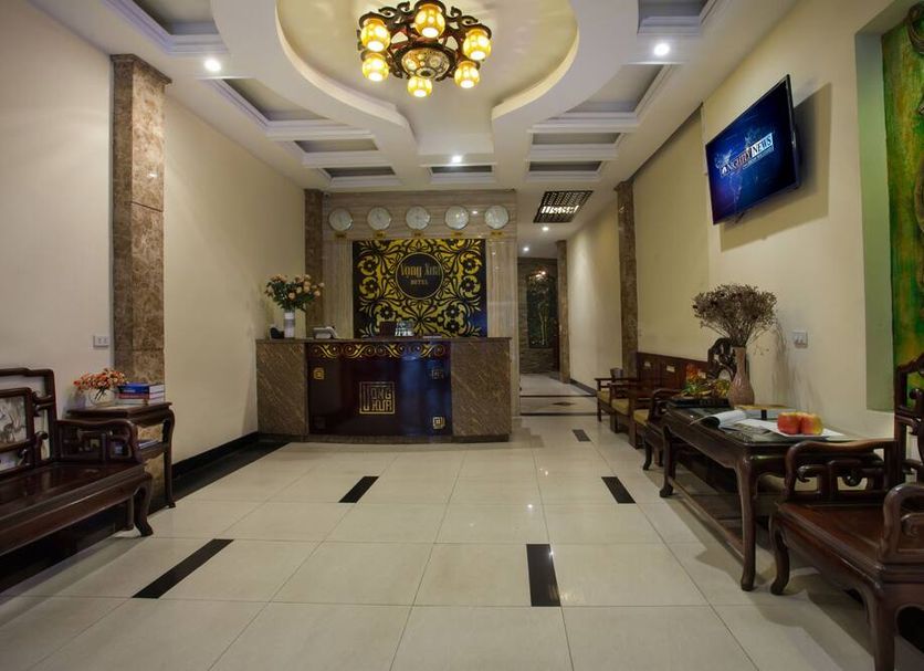 Vong Xua Hotel Hanoi lobby with ornate chandelier, reception desk, seating area, and wall-mounted TV