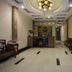 Vong Xua Hotel Hanoi lobby with ornate chandelier, reception desk, seating area, and wall-mounted TV