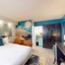Hotel Zazz in Albuquerque guest room with king bed, patterned wall art, and modern mural decor
