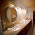 4 Seasons at Desert Breezes bathroom with double vanity, oval mirrors and wall sconces in Palm Desert