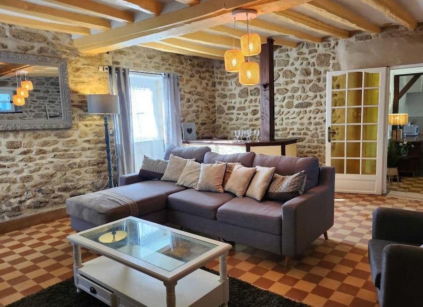 Le Clos Loret in Saint-Germain-du-Corbéis: rustic lounge with stone walls, sectional sofa and glass coffee table