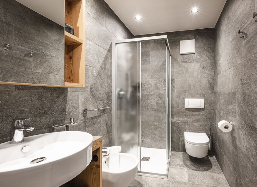 Hotel Lener, Mauls: modern bathroom with glass shower, wall-mounted toilet, sink and towel radiator
