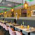 Leonardo Hotel Offenbach Frankfurt restaurant with long communal tables and pink chairs in Offenbach am Main