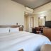 Hotel Route-Inn Iwakiizumi Ekimae guest room with bed, desk, TV, and wardrobe in Iwaki