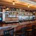 Inn on the Blues in Ogunquit bar with wooden counter, high stools, and shelves of liquor bottles