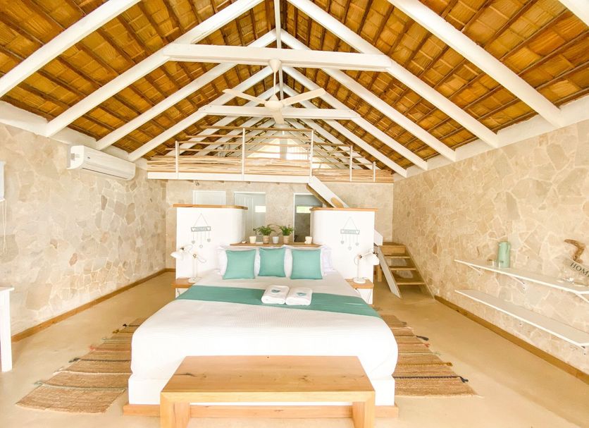 El Mosquito Boutique Hotel Playa Bonita in Las Terrenas: airy bedroom with vaulted wood ceiling and king bed