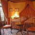 Hotel Torre di San Martino in Gazzola guest room with canopy bed, antique chairs and warm lamplight