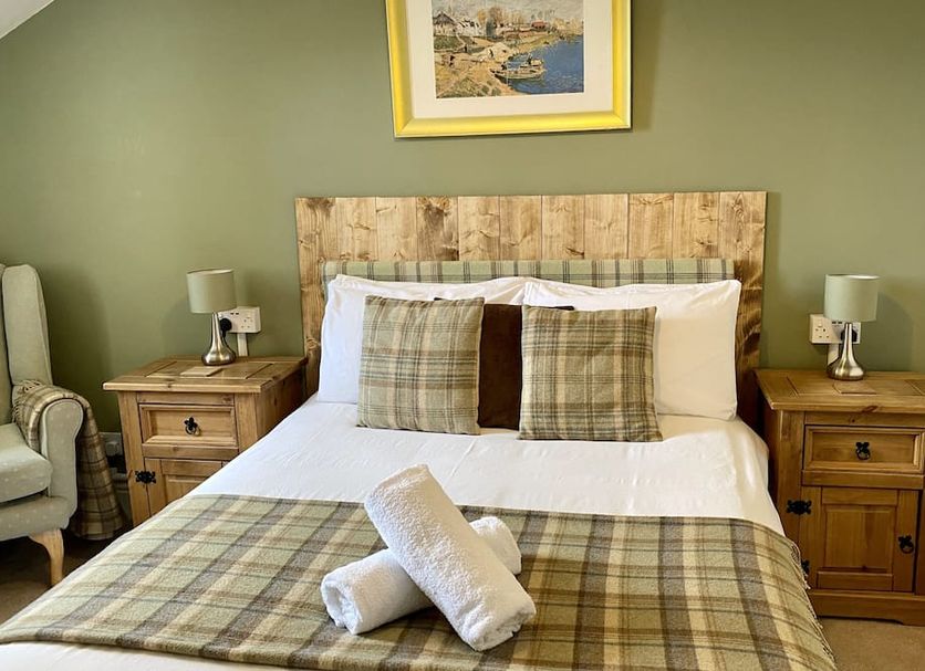 Number 19 Guesthouse, Dalton-in-Furness: twin bedside tables and a neatly made bed with plaid accents