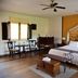 Hacienda La Magdalena Zapopan guest room with wrought-iron bed, seating area and yellow accent wall