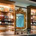 Naramata Inn bar with stocked liquor shelves, ornate mirror and polished counter in Naramata