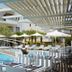Poolside lounge area at Renaissance Hanioti Resort in Afytos with umbrellas, loungers and a bridge
