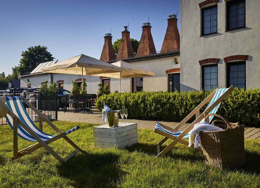 Kurort Stara Wedzarnia in Gdansk features a sunny garden patio with lounge chairs and umbrellas
