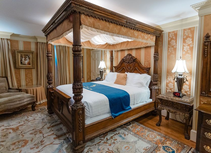1840s Carrollton Inn Baltimore four-poster bed in ornate guest room with patterned wallpaper