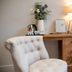 The Family Tree, Matlock: tufted chair beside wooden desk with lamp and flowers in a guest room