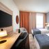Leonardo Hotel Vienna Hauptbahnhof guest room with two beds, desk, and window curtains in Vienna