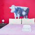 Art Factory San Telmo in Buenos Aires room with red cow mural behind a bed with folded towels
