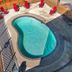 Express Inn & Suites San Antonio Near Sea World Medical Center pool with red lounge chairs and chain-link fence