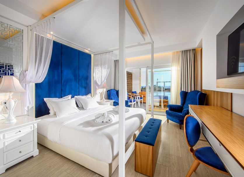 Minos Imperial Luxury Beach Resort & Spa Milatos bedroom with blue accents and balcony view
