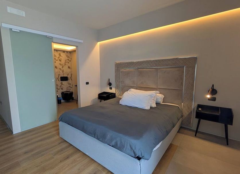 Hotel garni Santa Caterina in Orta San Giulio bedroom with king bed, warm lighting and wood floor