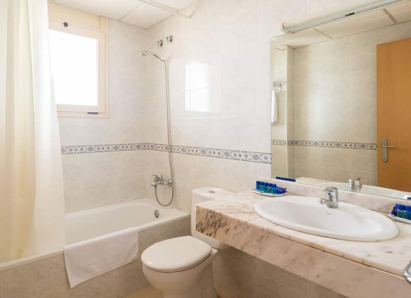 htop Royal Sun Suites bathroom with bathtub, sink, mirror and shower in Santa Susanna