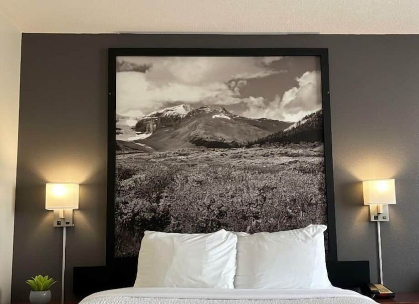 Super 8 by Wyndham Whitecourt room with mountain landscape wall art and twin beds