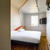 ibis budget Lyon Villeurbanne compact guest room with double bed, window, TV, and wall hooks