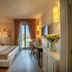 Palazzo San Lorenzo in Colle di Val d'Elsa guest room with balcony doors, desk, and floral wall art
