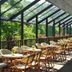 Hotel Smarjeta - Terme Smarjeske Toplice in Šmarješke Toplice: sunlit glass-enclosed terrace with tables and chairs