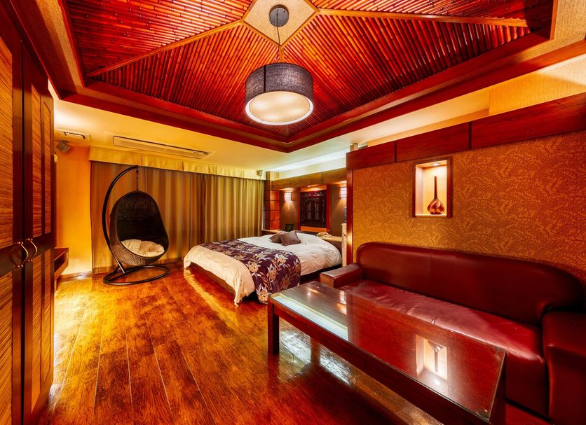 Hotel Lotus Otsu (Adult Only) guest room in Ōtsu with wood floors, canopy bed and hanging chair