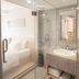 City Hotel Shanghai in Shanghai bathroom with glass shower, vanity sink, and toilet beside a bedroom