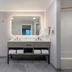 Homewood Suites by Hilton Fresno bathroom with walk-in shower, double vanity, and large lit mirror