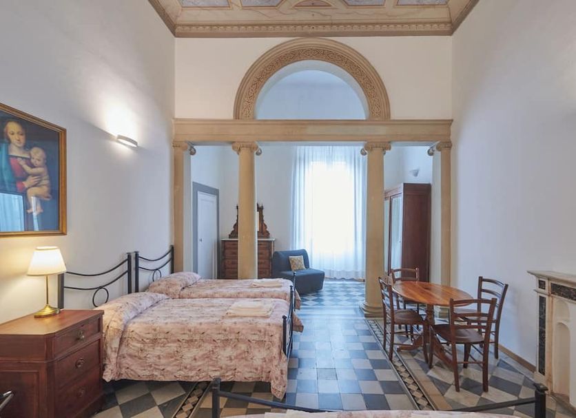 Casa Santo Nome di Gesu Florence room with twin beds, arched window, and small dining table