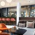 Leonardo Hotel Vienna Hauptbahnhof lobby bar with orange stools and lounge seating in Vienna
