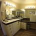 Ridgemark Golf Club And Resort in Hollister bathroom with dual sinks, large mirror, vanity lights and shower area