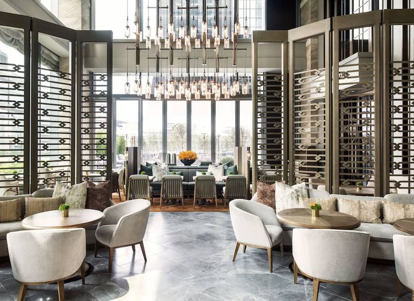 The St. Regis Hong Kong lounge with chandeliers, round tables and city-view windows in Hong Kong
