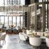 The St. Regis Hong Kong lounge with chandeliers, round tables and city-view windows in Hong Kong