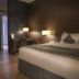 Asdal Boutique Hotel Seef in Manama guest room with king bed, desk, and warm wood-accented decor