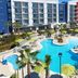 SpringHill Suites by Marriott Orange Beach at The Wharf pool courtyard with palm trees and lounge chairs