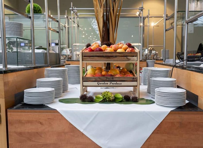 Eventhotel Pyramide in Vienna breakfast buffet with fruit display and stacks of white plates