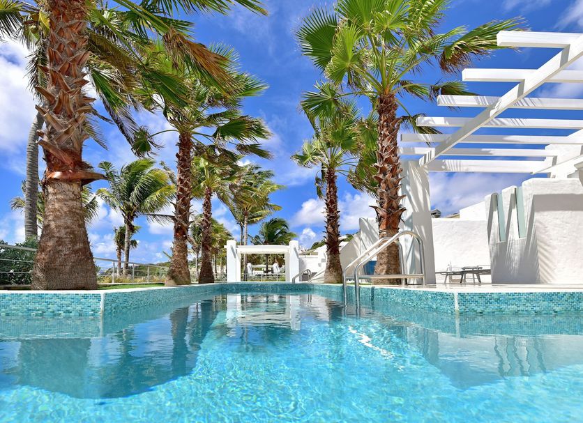Coral Beach Club Villas & Marina in Upper Prince's Quarter, poolside view with palm trees and oceanfront cabana
