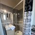 Hotel De l'Univers in Caen bathroom with glass shower, vanity sink, mirror and patterned curtain.