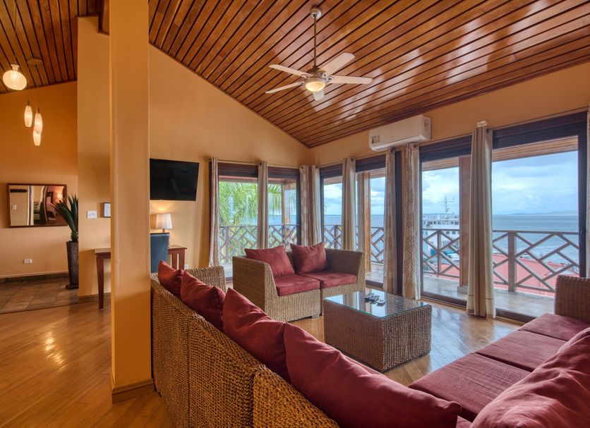 Hotel Palma Royale in Bocas del Toro living room with ocean-view balcony and ceiling fan