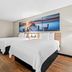 Days Inn by Wyndham Jacksonville NC guest room with two beds and sunset pier wall art