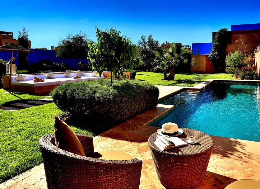 Al Maaden Villa Hotel & Spa Marrakech poolside lounge with garden, sunbeds and turquoise pool