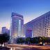 Henan Sky-Land Gdh Hotel in Zhengzhou at dusk with illuminated high-rise exterior and city traffic streaks