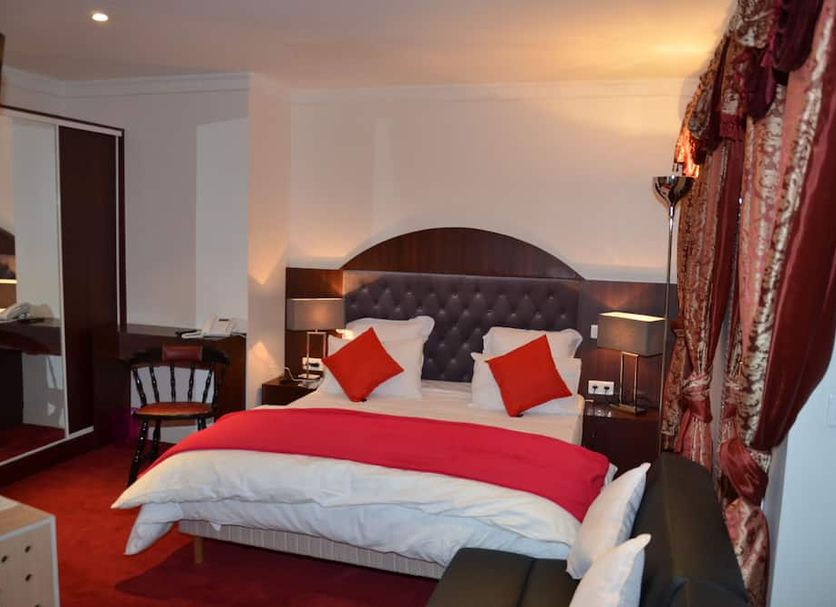 Hotel Regina Montmartre Paris guest room with double bed, red bedding, and bedside lamps