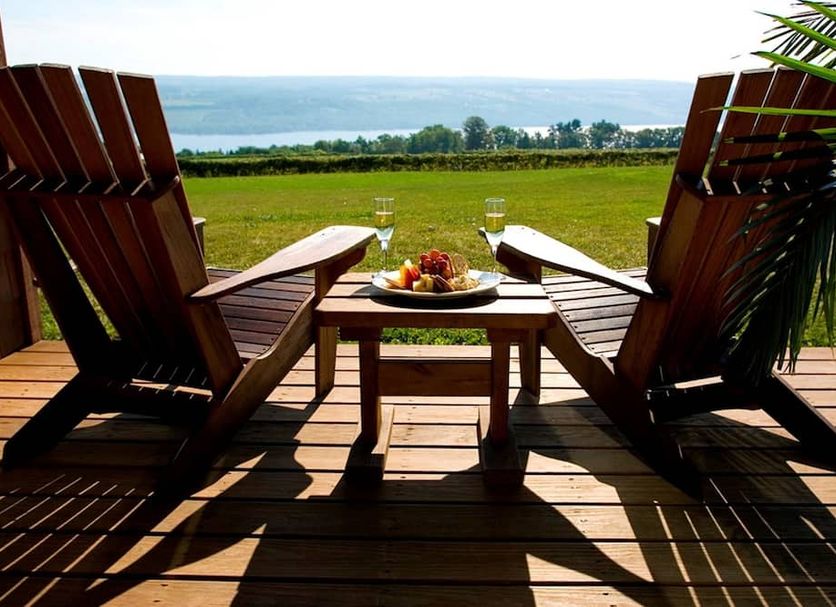 The Inn at Glenora Wine Cellars in Dundee: Adirondack chairs on a deck overlooking the lake and vineyard.