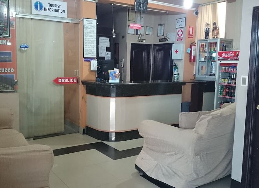 Hotel Savoy in La Paz lobby with front desk, beige armchairs and tourist information sign