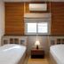 The Goose House Ubon room in Ubon Ratchathani with two beds, nightstand, window and air conditioner