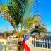 Hostel Dos Gringos in Maricá with palm-lined beachfront, white picket fence, and ocean view